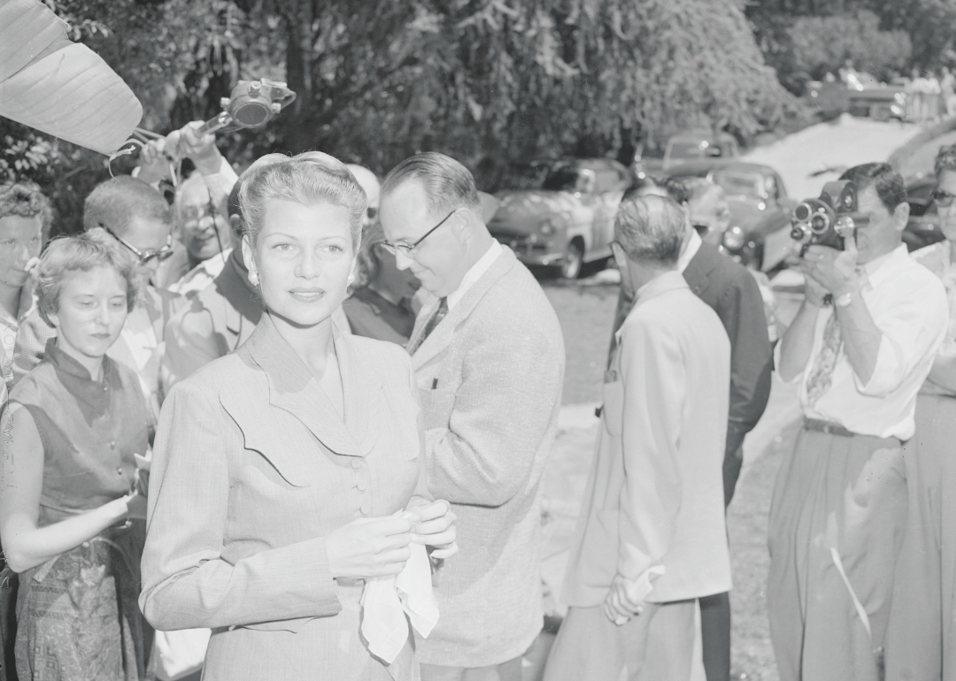 Rita Hayworth surrounded by photographers.