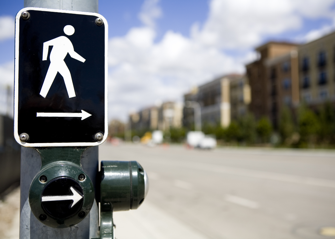 A lit pedestrian crosswalk sign on a road. 