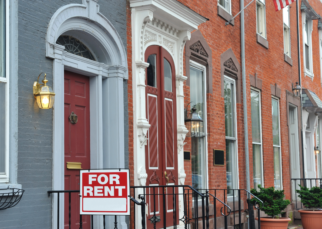 A for rent sign in front of brick apartments. 
