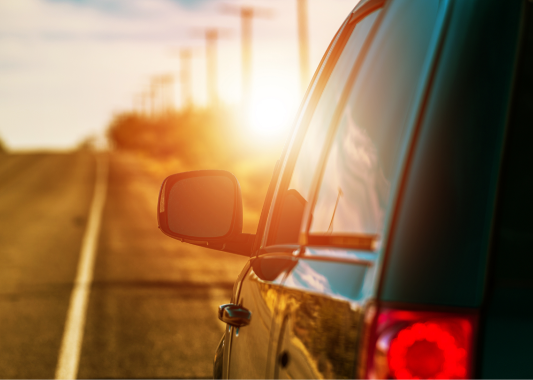 A car sits on a road in the hot sun.