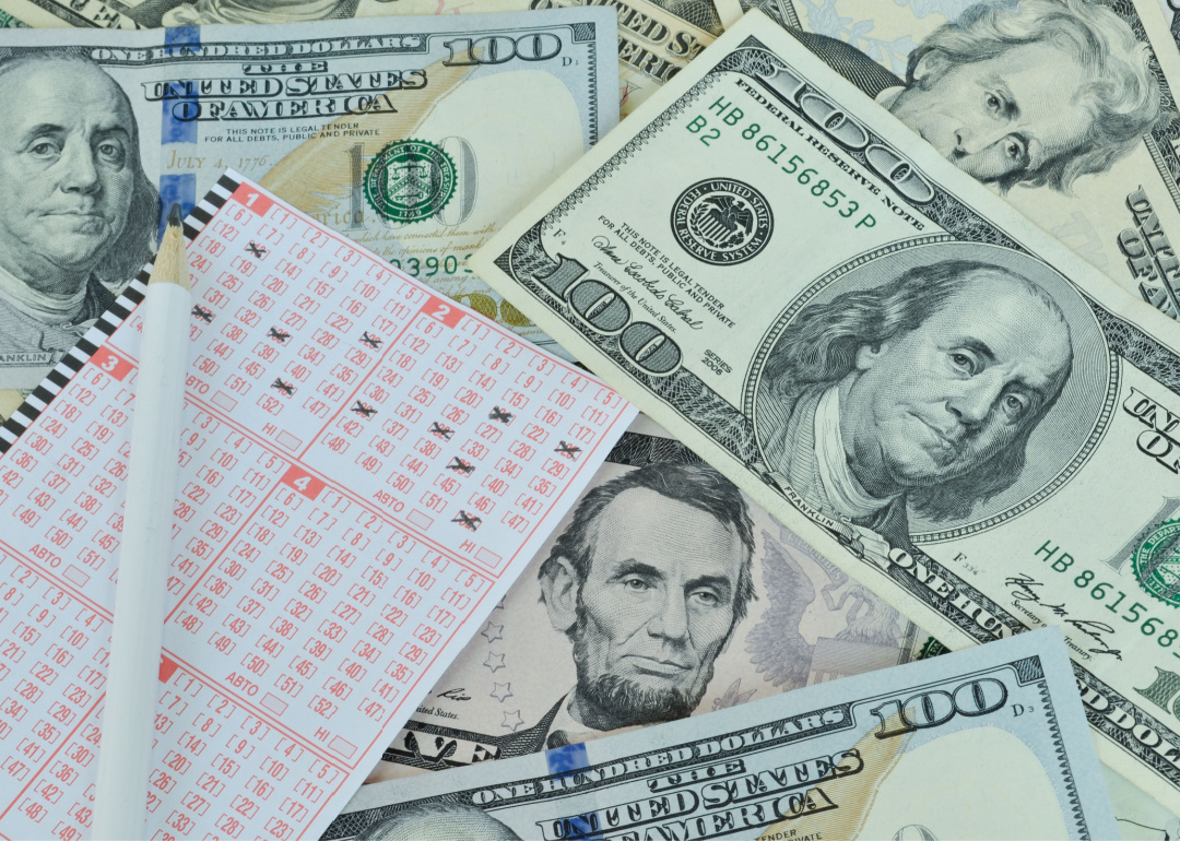 A Powerball ticket lying atop a pile of cash.