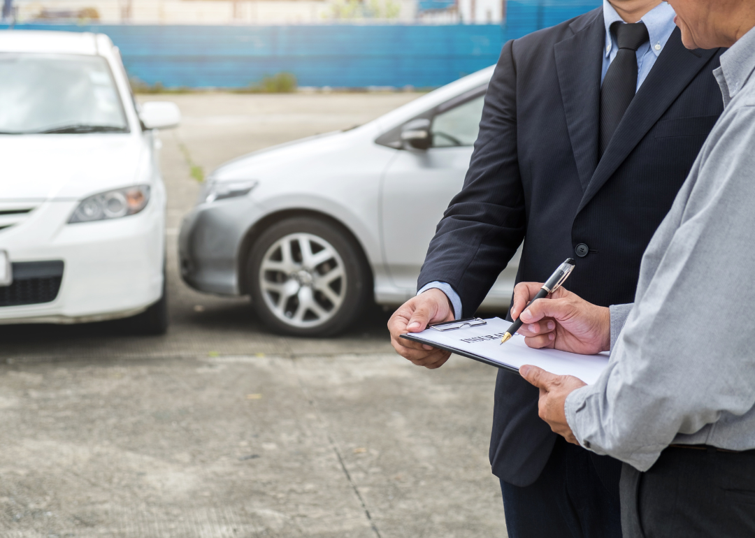 A person filling out an insurance claim after an accident.