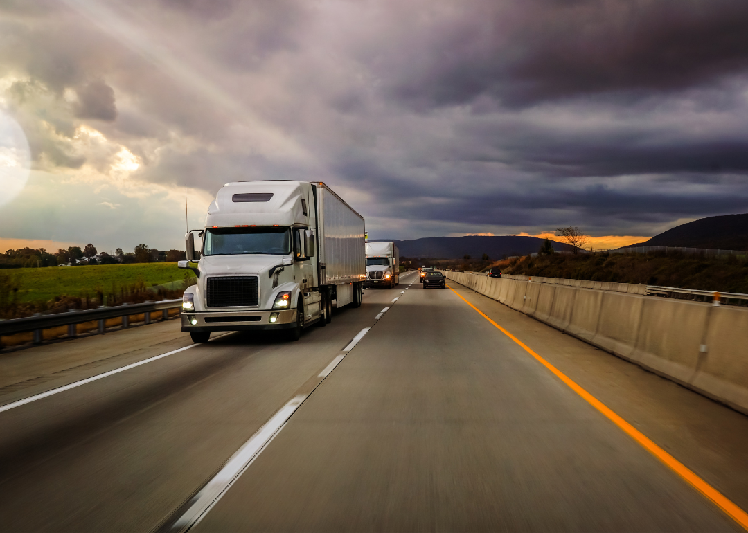 Two 18-wheelers on a highway platooning.