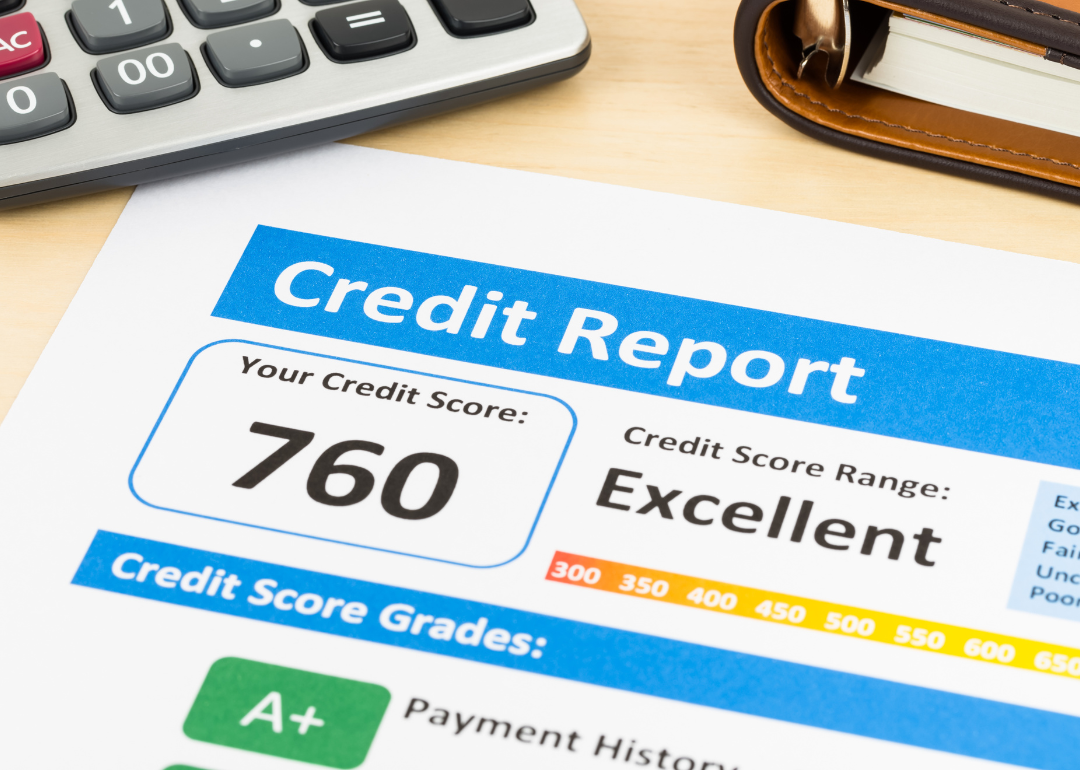 A credit score report of 760 with a calculator and organizer book.