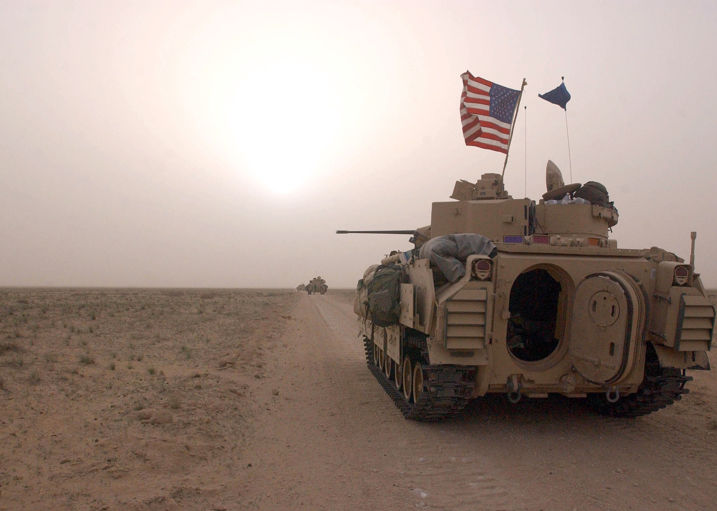 U.S. Army 3rd Division 3-7 Bradley fighting vehicles take up a position along a road.