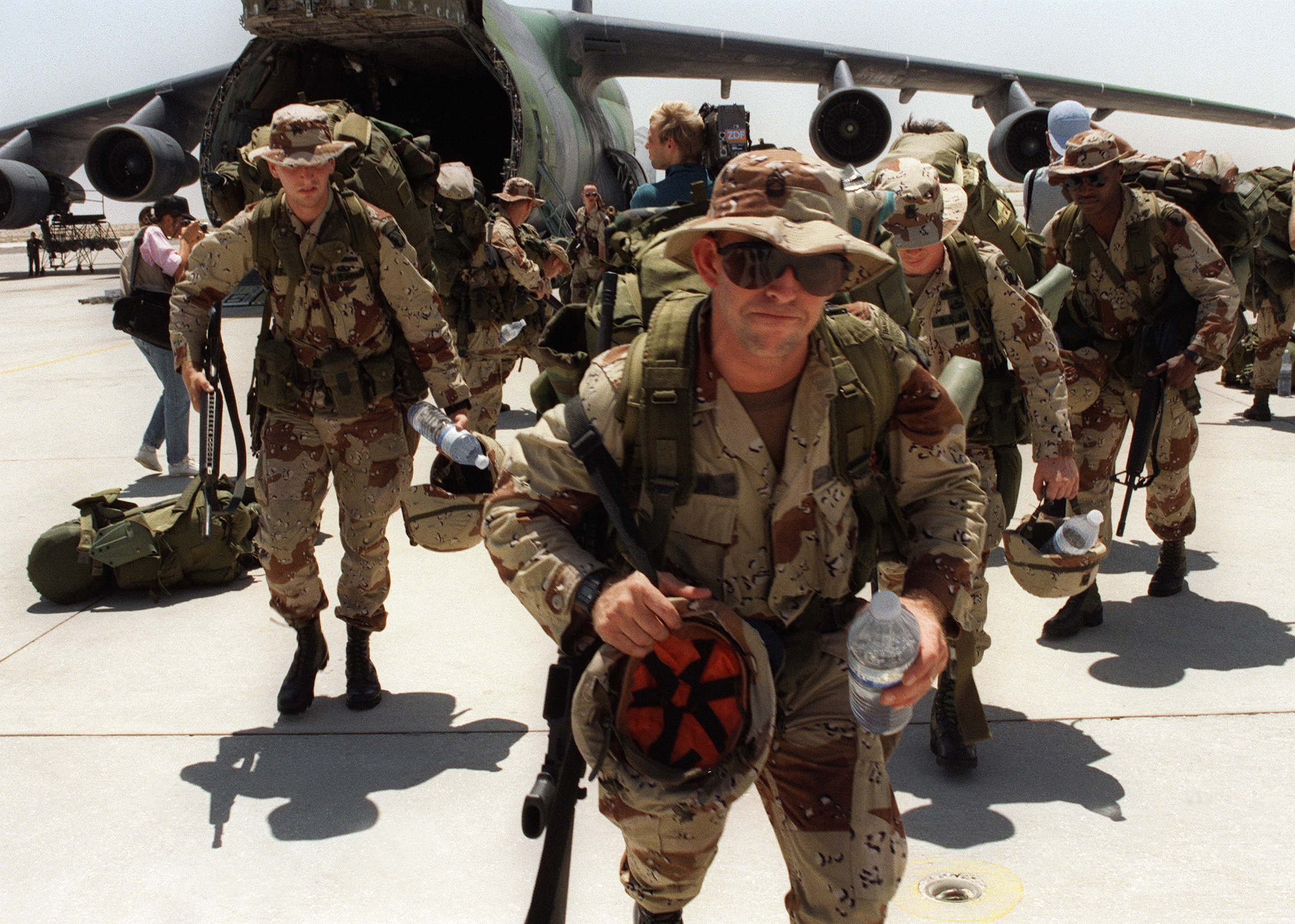 Marines disembark from a transport plane at Dhahran air base.