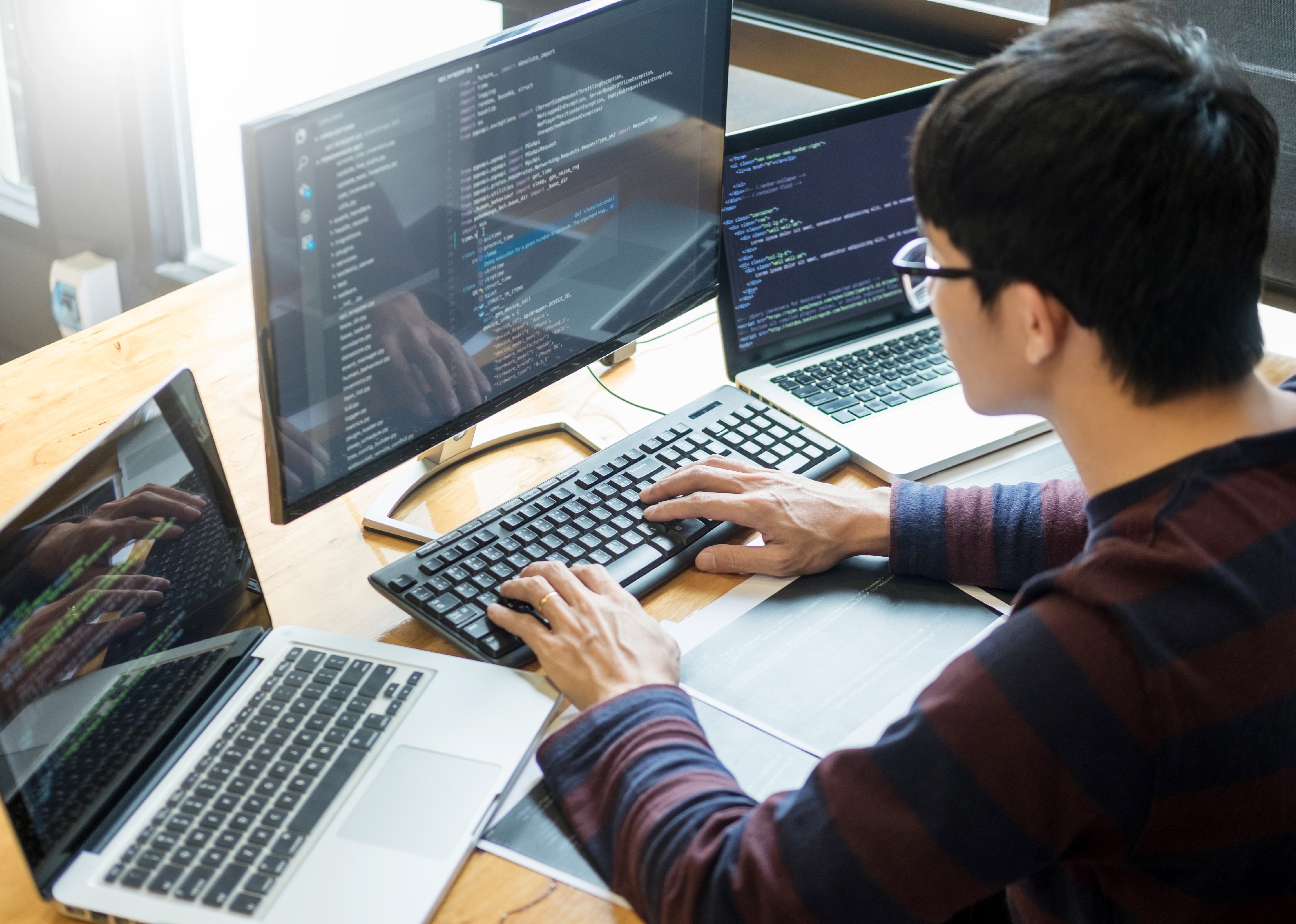 Programmer working on on desktop programming code.