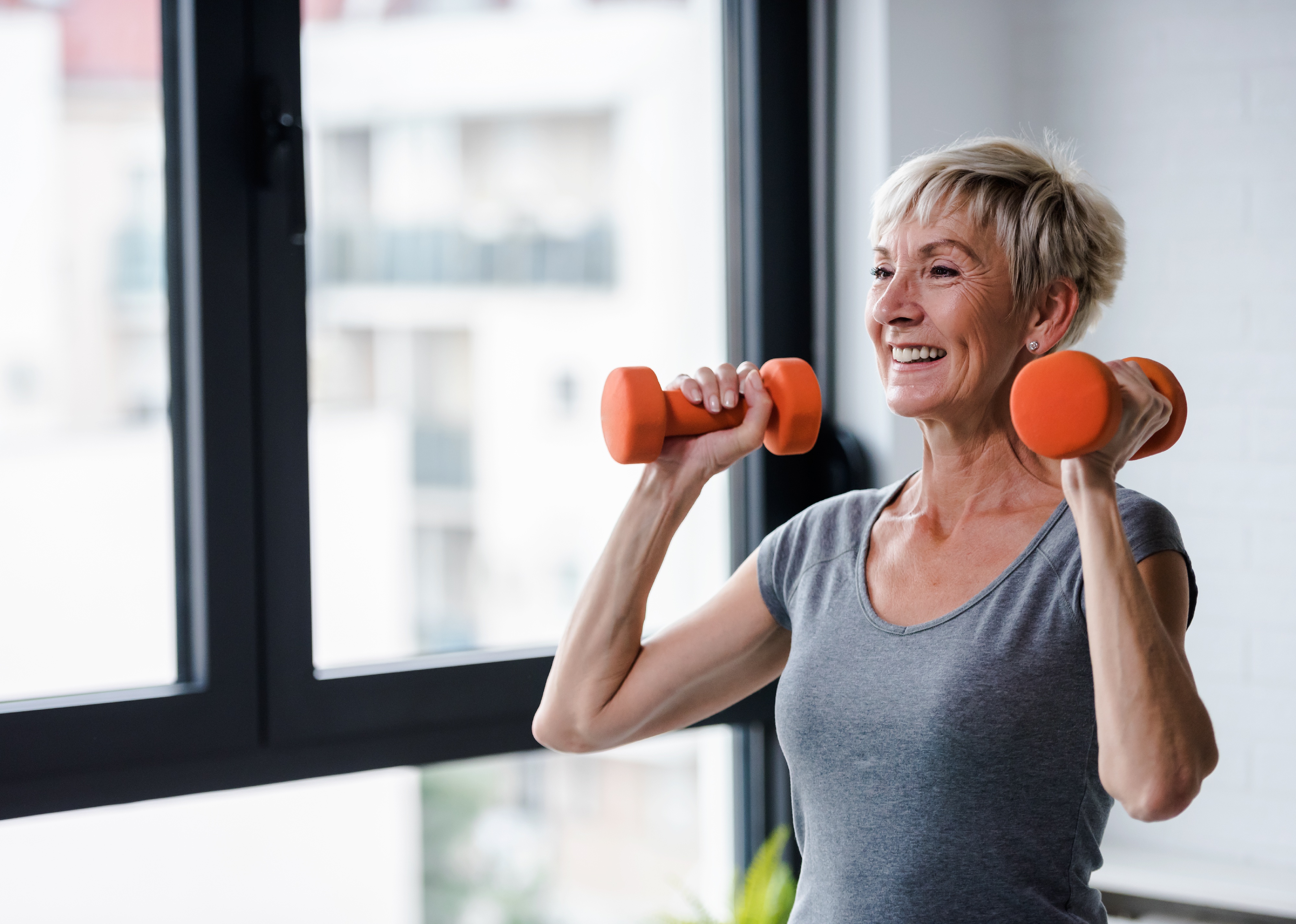 Portrait of senior woman lifting dumbbells.
