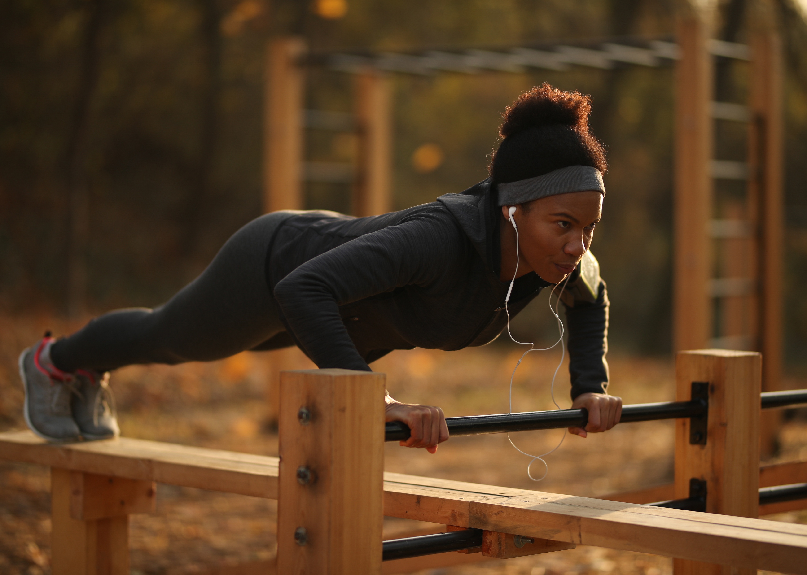 Woman doing push-ups while exercising in a park.