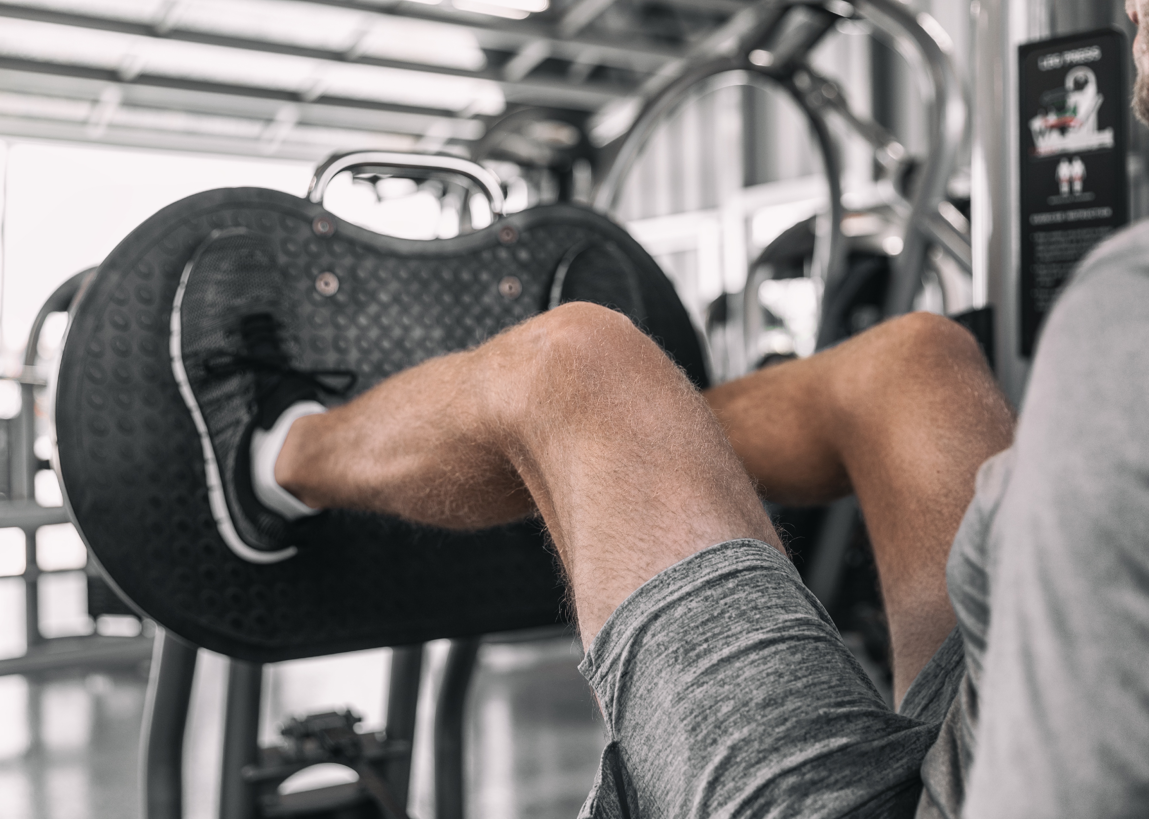 Man using leg press in gym.