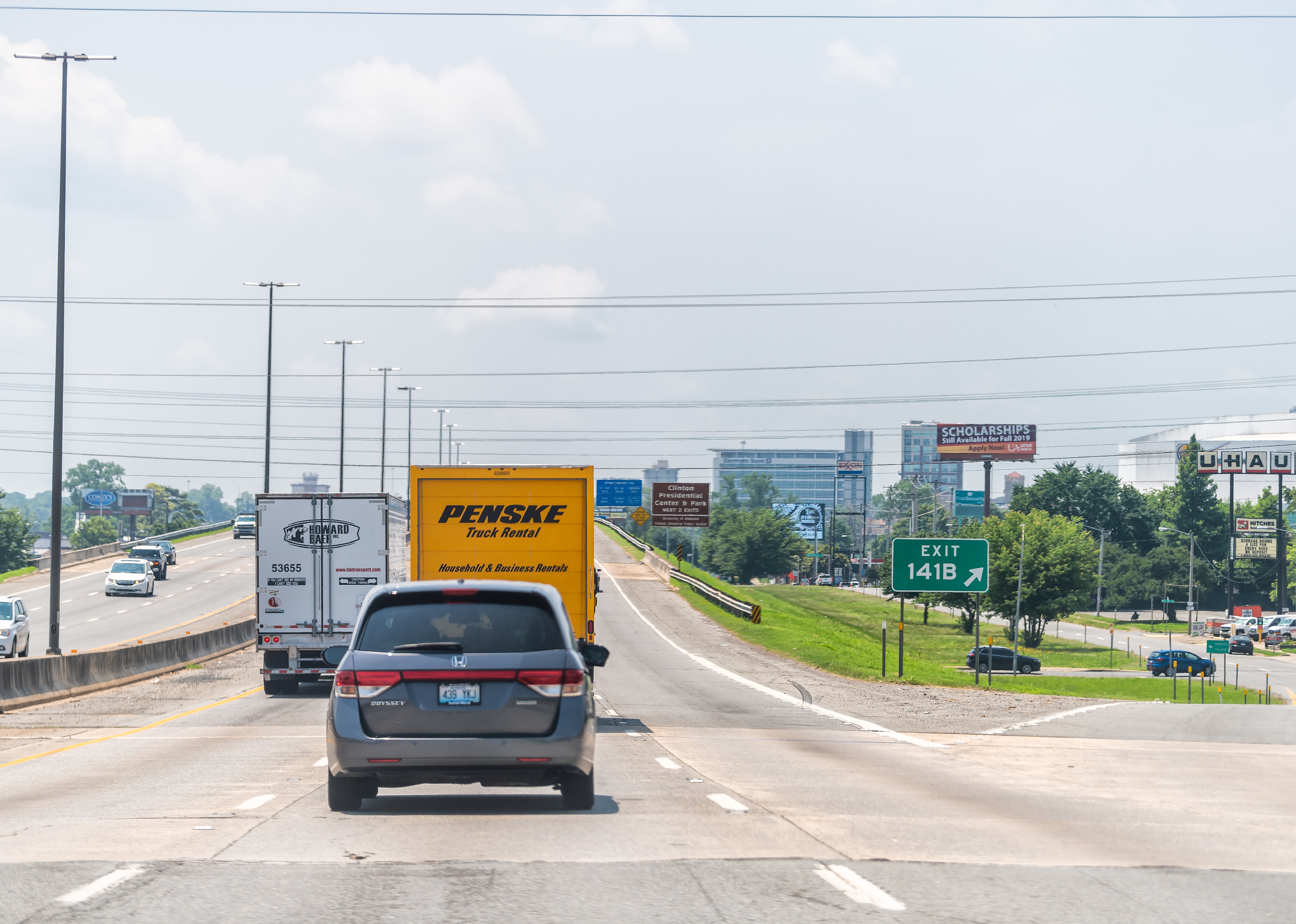 Capital city in Arkansas with exit sign and cars in traffic.
