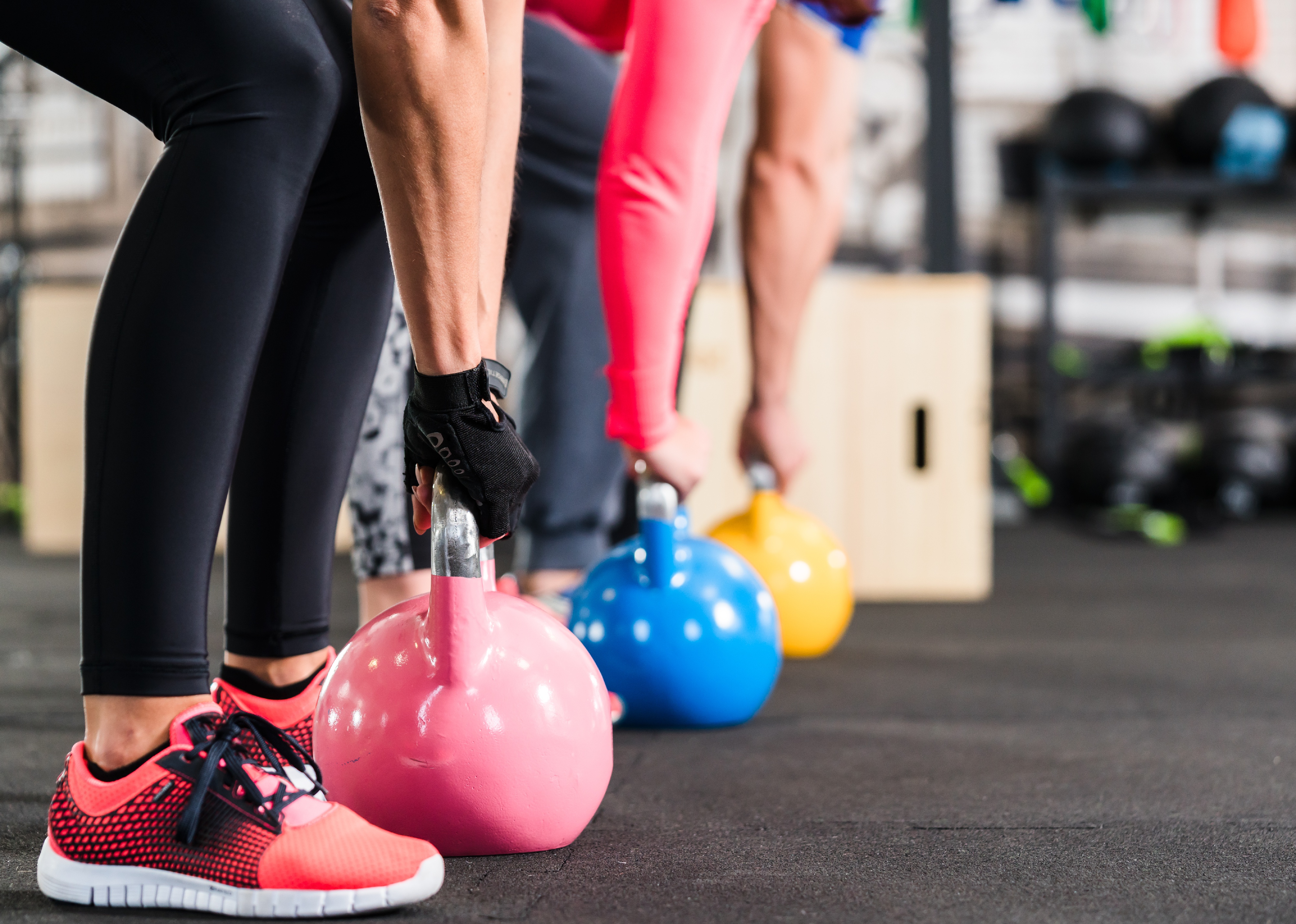Group of people in fitness class, training with kettlebell.