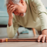 Senior man lying on the floor with walker after having fallen.