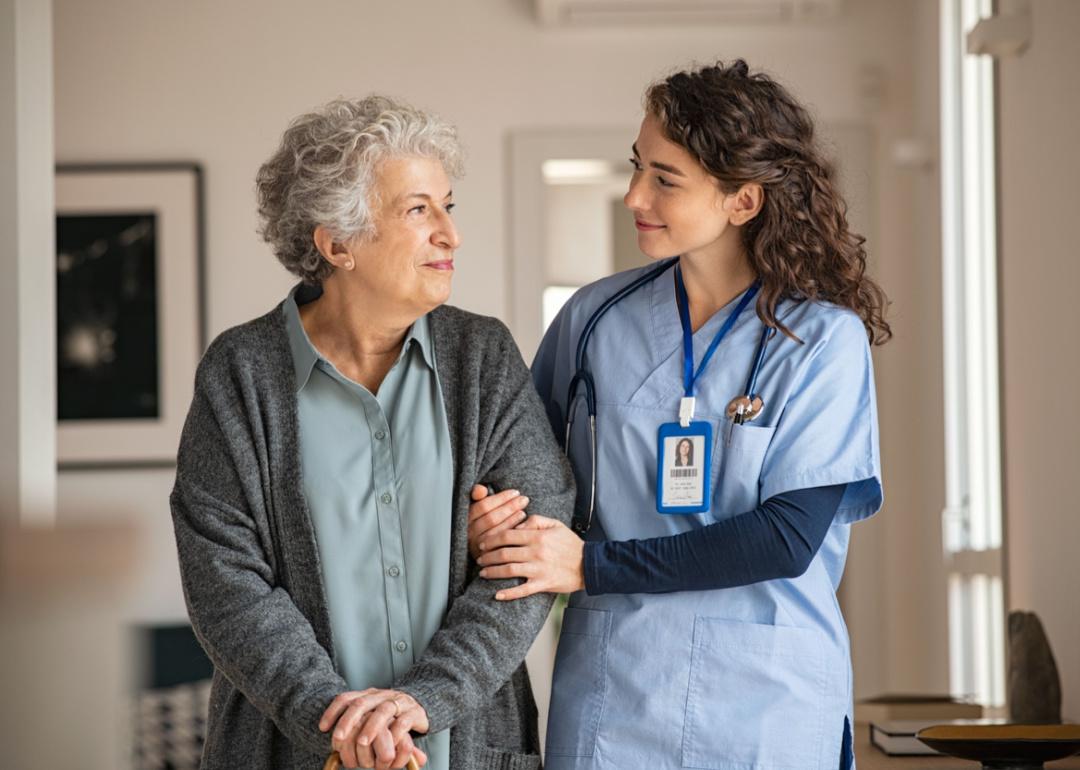 Nurse walking with senior patient.