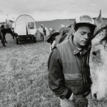 Young man nuzzling up to his horse in open field while reenacting the Trail of Tears journey in 1988.