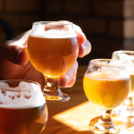 Person holding glass of beer at sampling.