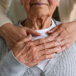 Caring hands holding elder family member.