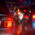Red car brake lights on busy road at night  