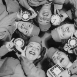 Air line stewardesses posing with clocks before time change.