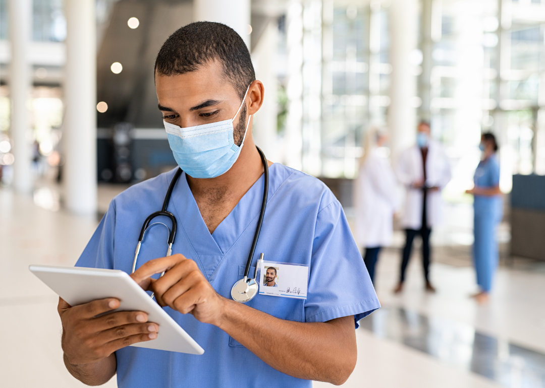 Nurse in hospital checking tablet.