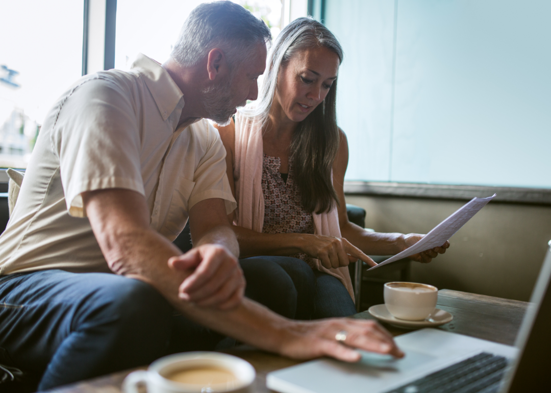 A middle-aged couple reviews financial documents