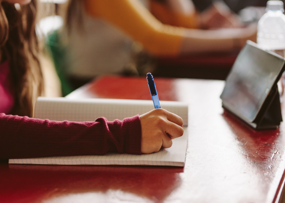 Closeup of female student hand writing in notebook