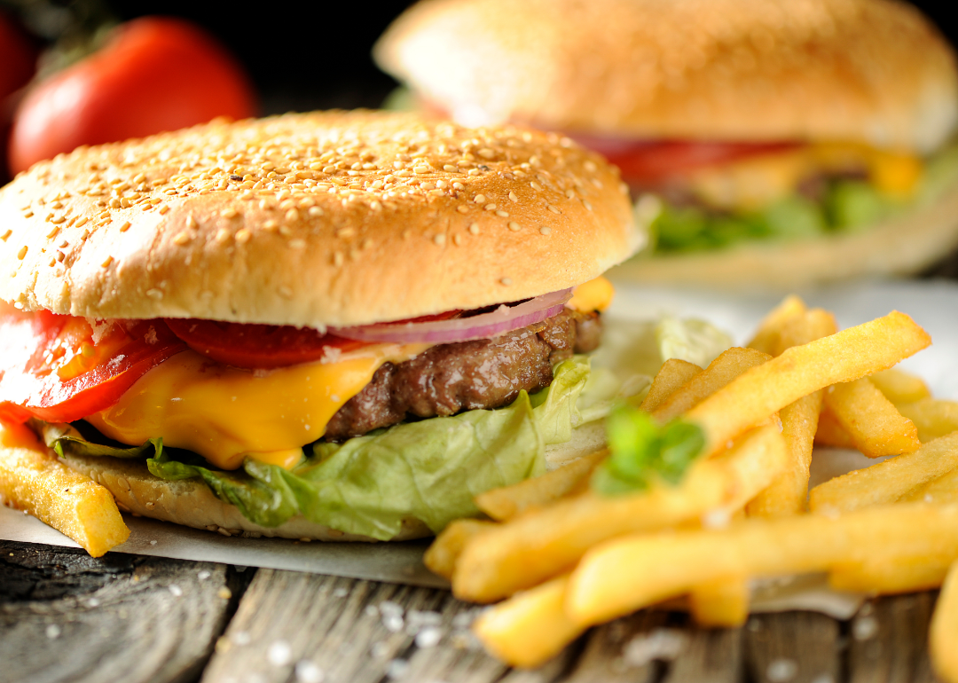 A cheeseburger and french fries on a wooden surface.
