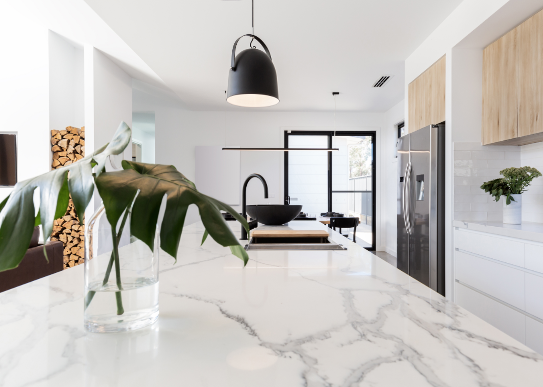 Modern kitchen with white marble countertops.