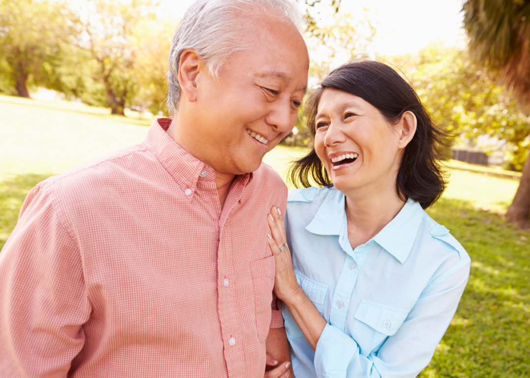 A senior couple walking in a city park.