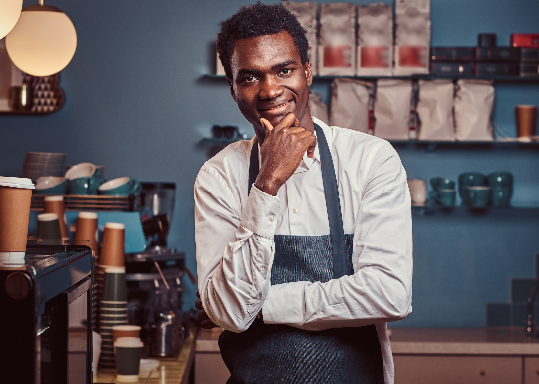 A smiling business owner standing in his cafe. 