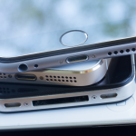 A close-up of a stack of smartphones on a desk.