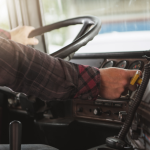 Trucker behind truck steering wheel.