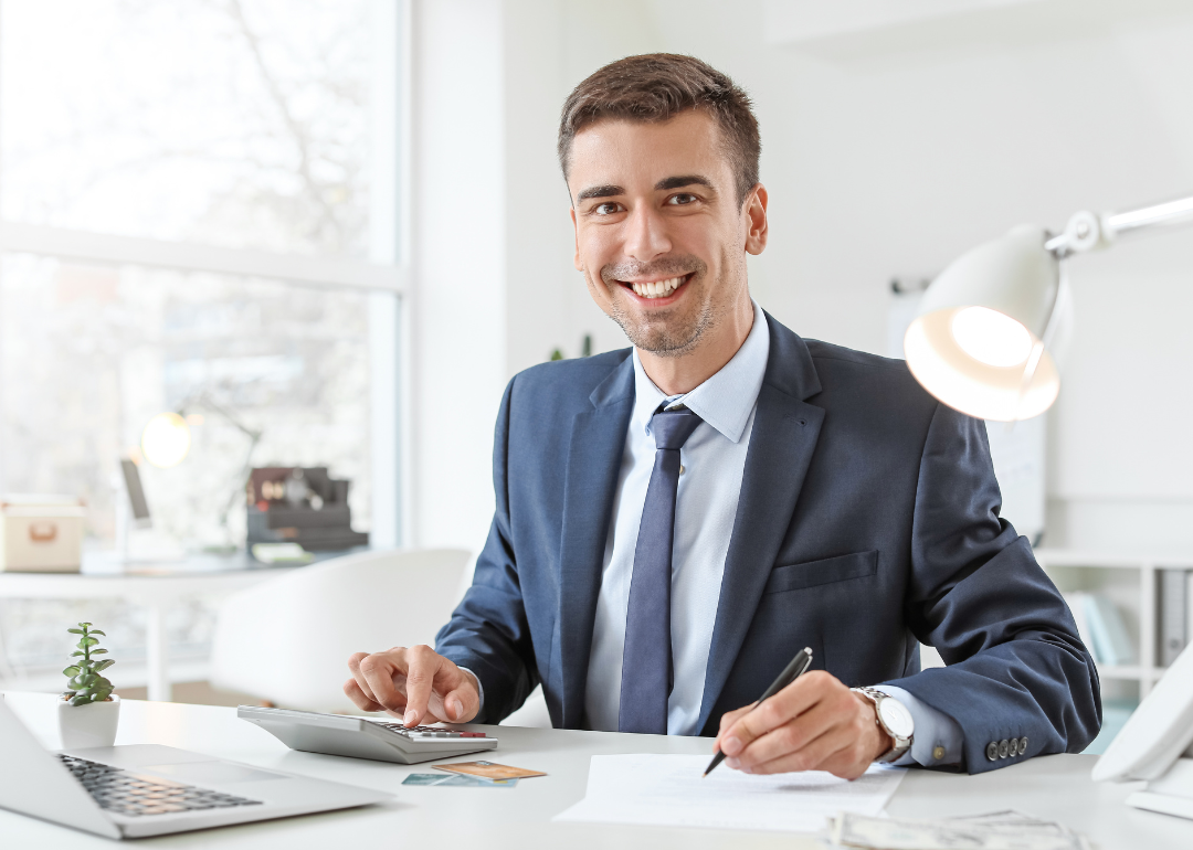 Banker smiling at his desk. 