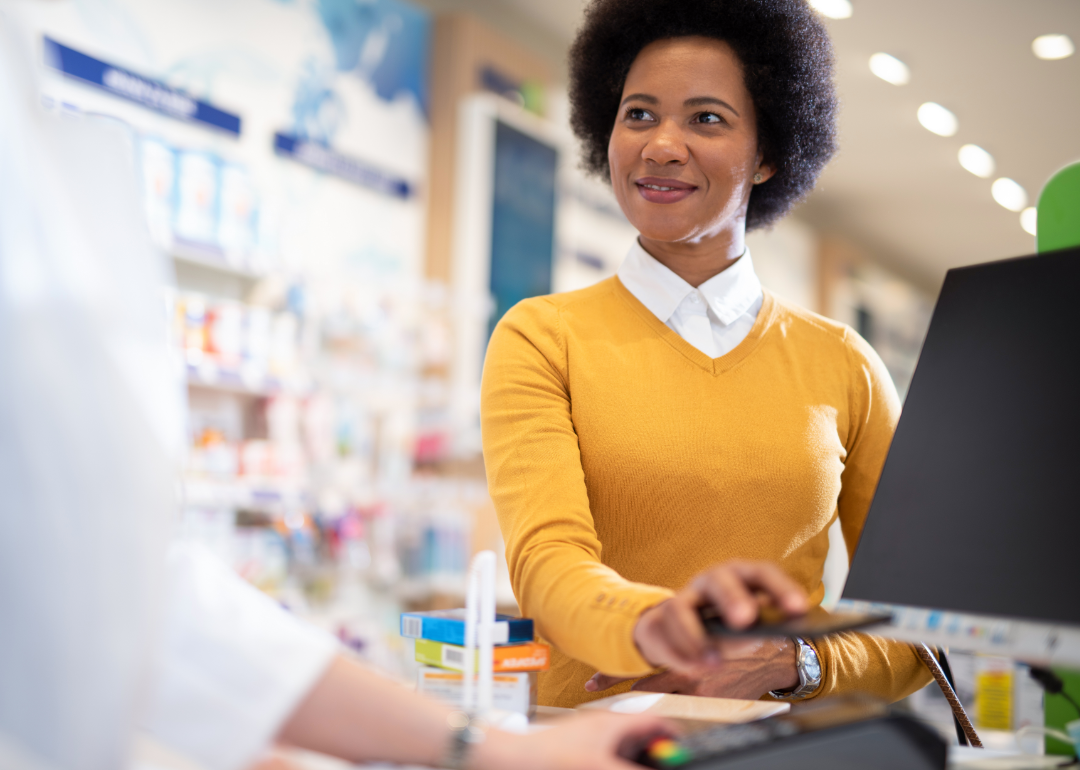 A woman pays for medicine at a pharmacy. 