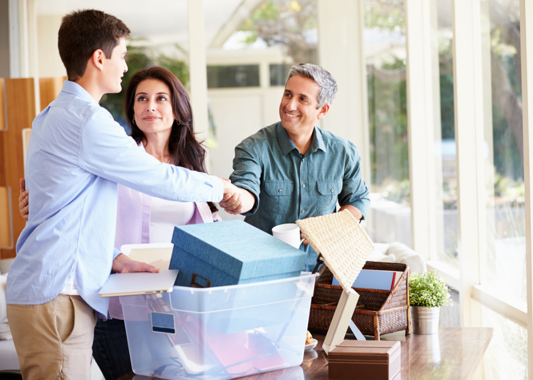 Parents with college student packing a box.