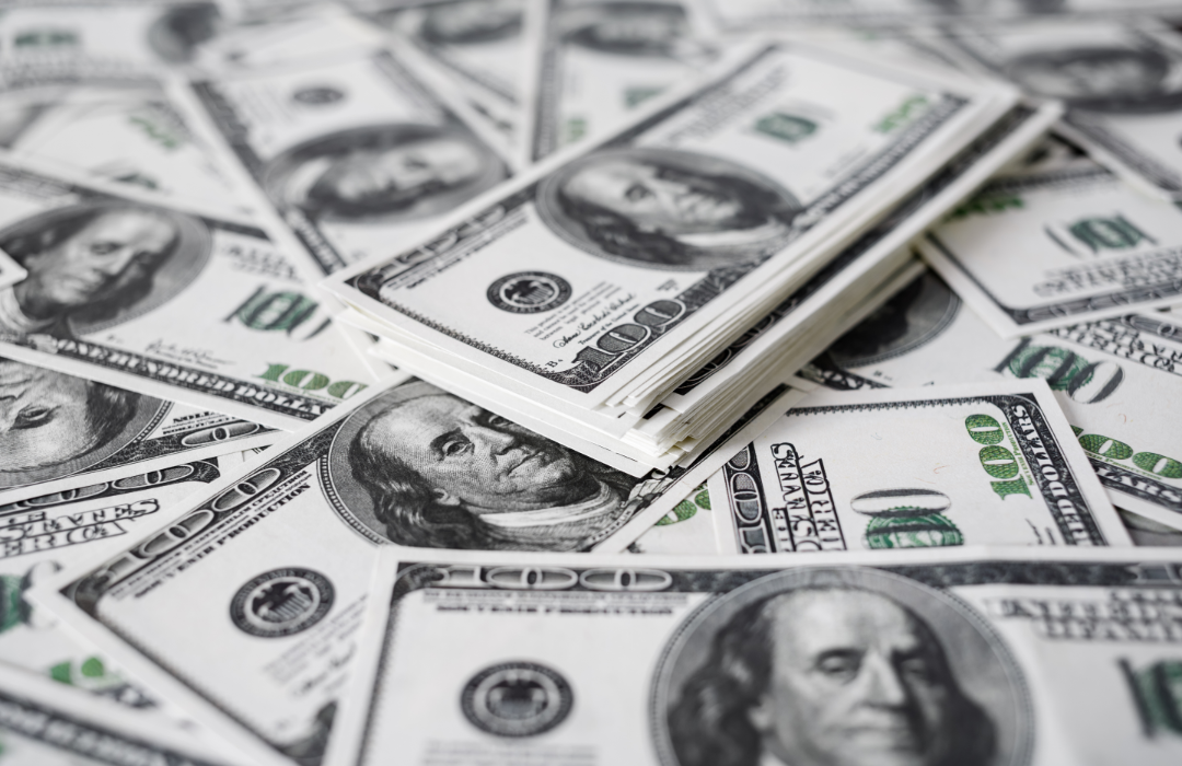 Piles of 100-dollar bills shown face up.