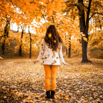 A woman standing in a forest in autumn