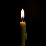 A lit candle against a black background