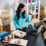 A female small business owner prepares to drop ship products ordered online from her store.