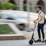 A man rides an e-scooter in a city