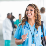 A female nurse with brown hair looking off-camera and smiling