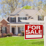A For Sale sign in front of a single-family home