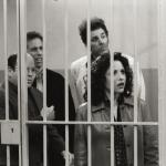 Actors Jason Alexander (George), Jerry Seinfeld (Jerry), Michael Richards (Kramer), and Julia Louis-Dreyfus (Elaine) stand behind bars in a scene from the final episode of 'Seinfeld.'