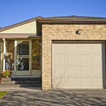 A brown brick starter home with one-car garage