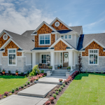 A large home centered in a green lawnscape