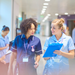 Two nurses comparing notes
