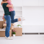 A young couple hug as they move into a new home