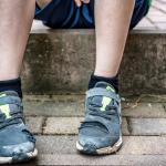 A child sits with torn shoes as a symbolic image on the subject of child poverty.