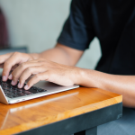 closeup hands of student on a laptop at a desk