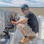 HVAC tech checking on condensing unit on roof